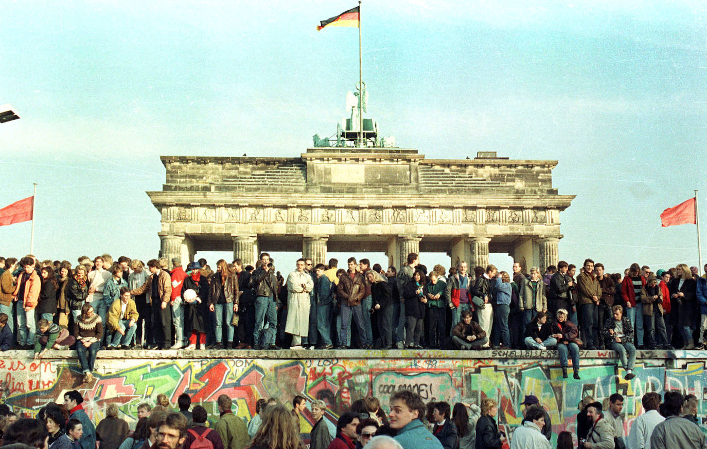 (2) Antes: Los ciudadanos de Berlín Occidental continúan su vigilia sobre el Muro de Berlín frente a la Puerta de Brandenburgo, el 10 de noviembre de 1989.