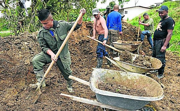 Exmiembros de las FARC trabajan en una zanja dentro de otro centro ETCR. 