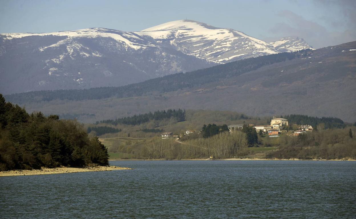 El embalse de Urrunaga, con Elosu en su orillas y la cumbre del Gorbea nevada al fondo. 