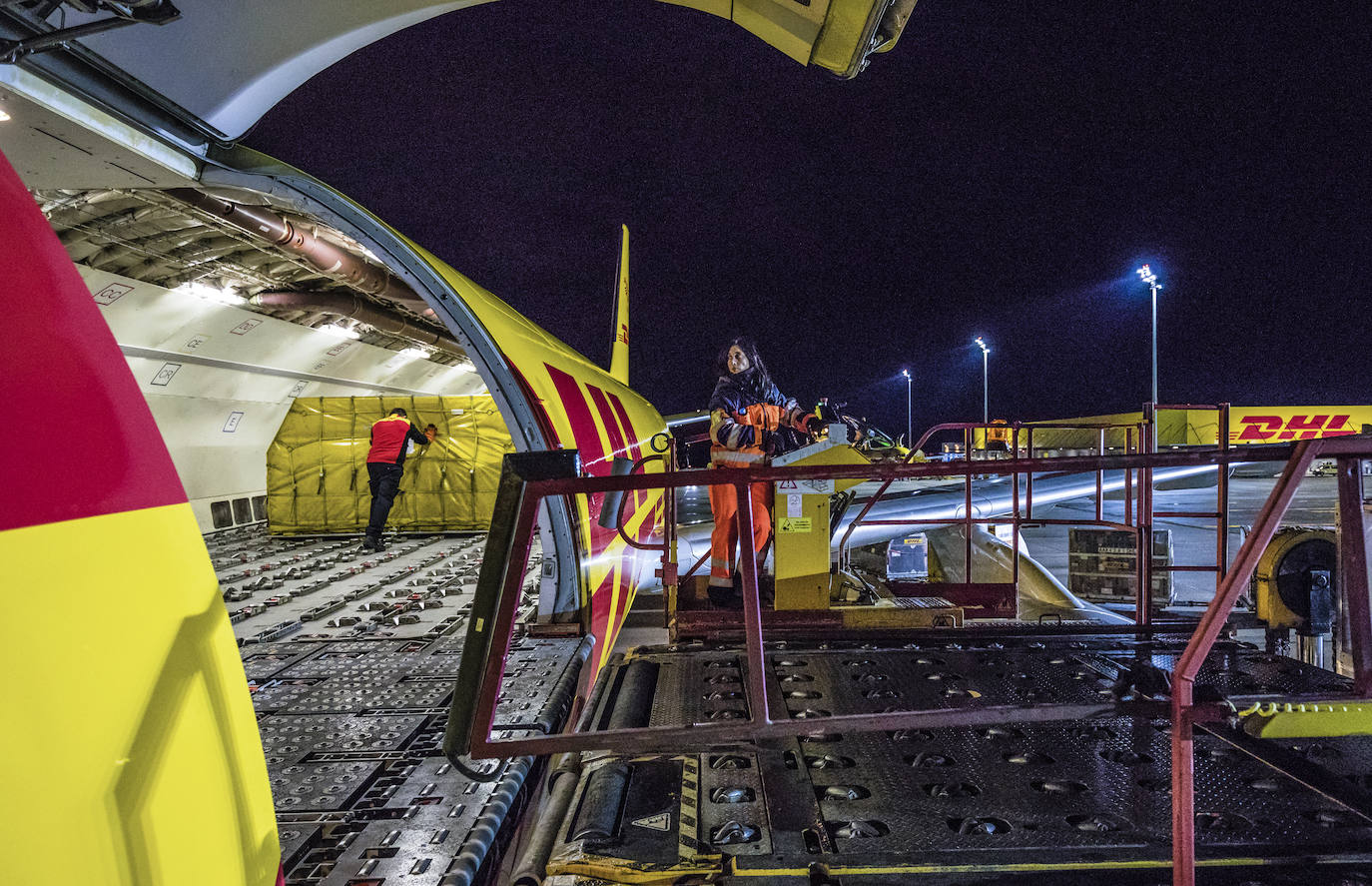 Operarios descargan la mercancía del Airbus A-300 de DHL.