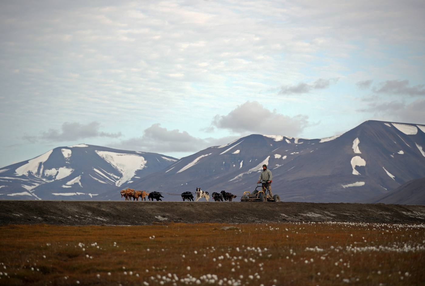 Un hombre va con sus perros en trineo por Longyearbyen (Noruega). El calentamiento del planeta es muy evidente en esta zona y sus habitantes están muy preocupados por lo que creen que es el final de su forma de vida. 