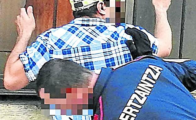 Un ertzaina registra a un detenido, en una foto de archivo. 