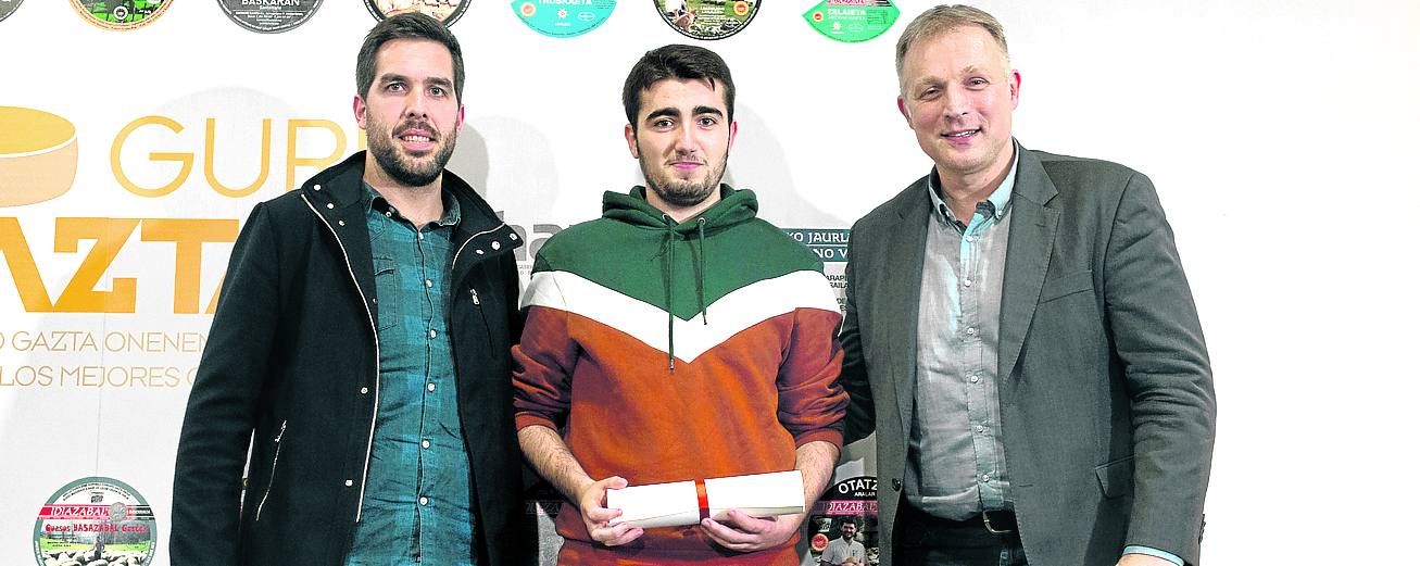 Iñigo Sanjuan (Basazabal Gazta), escoltado a la izquierda por el aizkolari Aitzol Atutxa y a la derecha por el director general del Bilbao Basket, Predrag Savovic, tras recibir el diploma.