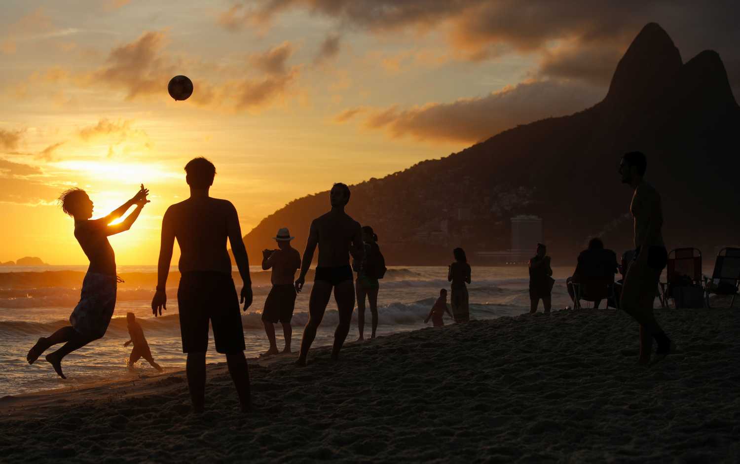 Jugando al fútbol con una puesta del sol en la playa de Ipanema en Río de Janeiro