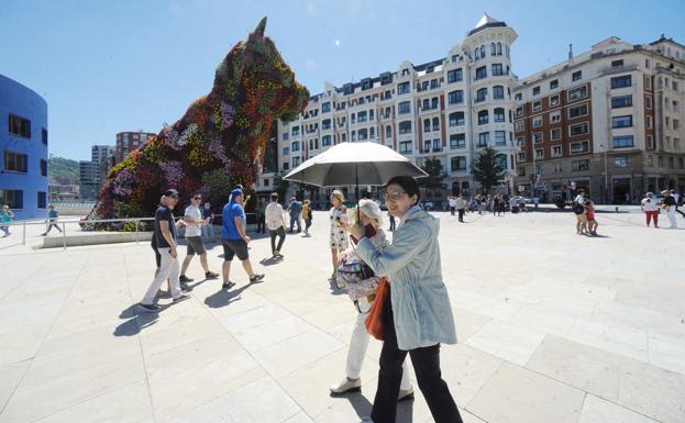 Unos turistas pasan frente al Guggenheim. 