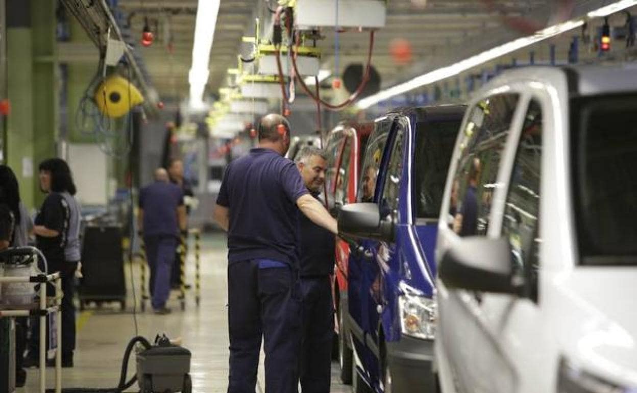 Varios trabajadores en una fábrica de coches.