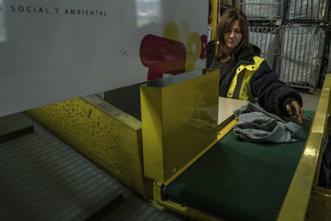 Mari Luz revisa los pantalones de Raquel antes de su procesamiento. 10.000 kilos de ropa llegan cada día a la planta de Mungia.