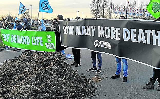 Activistas vuelcan un camión de estiércol a las puertas de Ifema, en protesta por los escasos avances de la COP25. 
