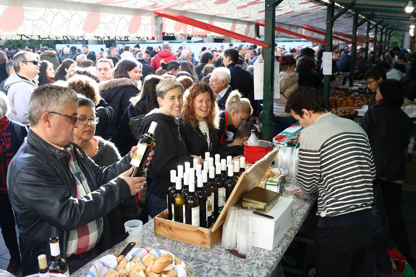 Una pareja elije una botella de txakoli.