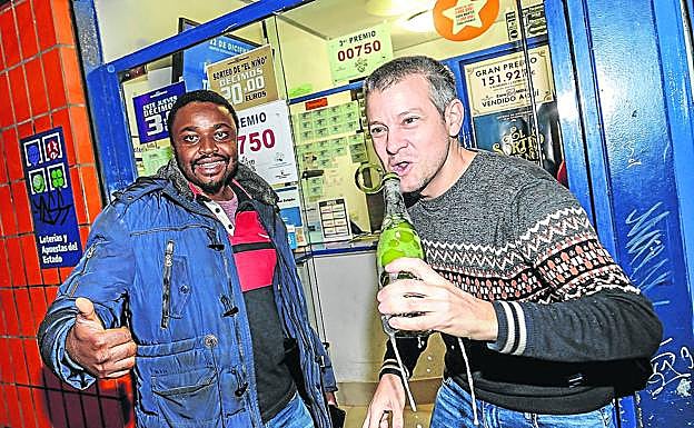 Prosper Tchanko celebra con su amigo, el lotero Juan Carlos de Quintana, el tercer premio en la administración número 1 de Vitoria, en el pasaje de Postas. 