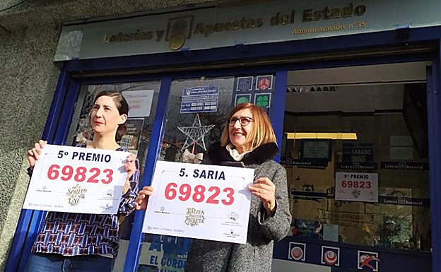 Galería. Ainize, a la izquierda y muy emocionada, sujeta un cartel con el número premiado.