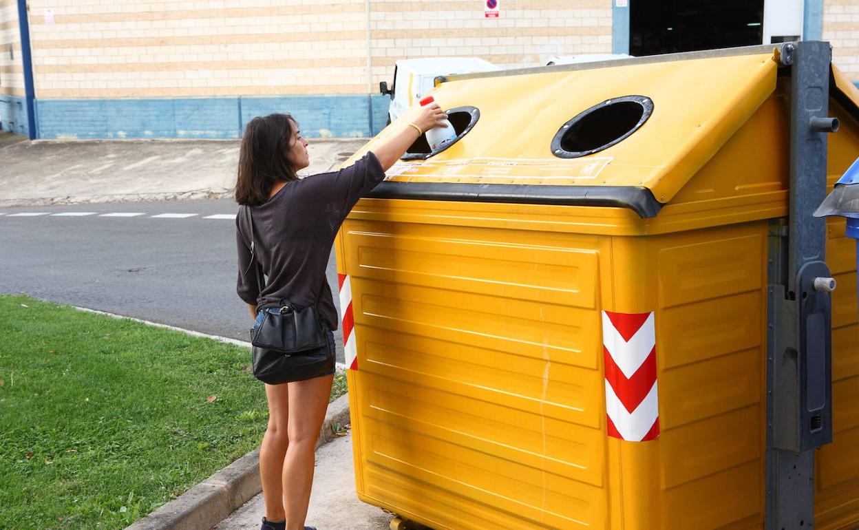 Emakume bat ontzi bat edukiontzi horian uzten. 