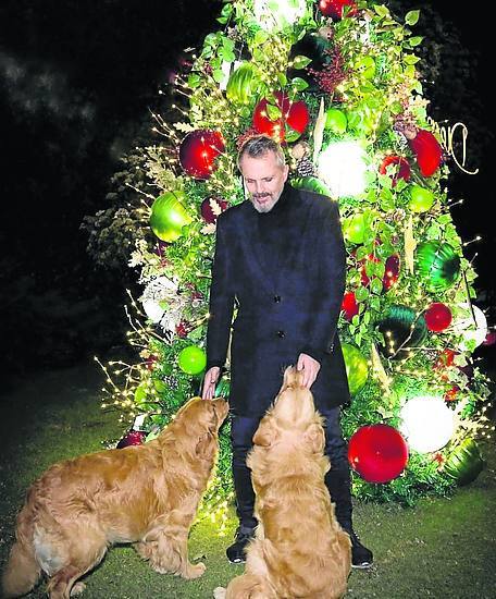 Miguel Bosé, en su jardín con sus perros.