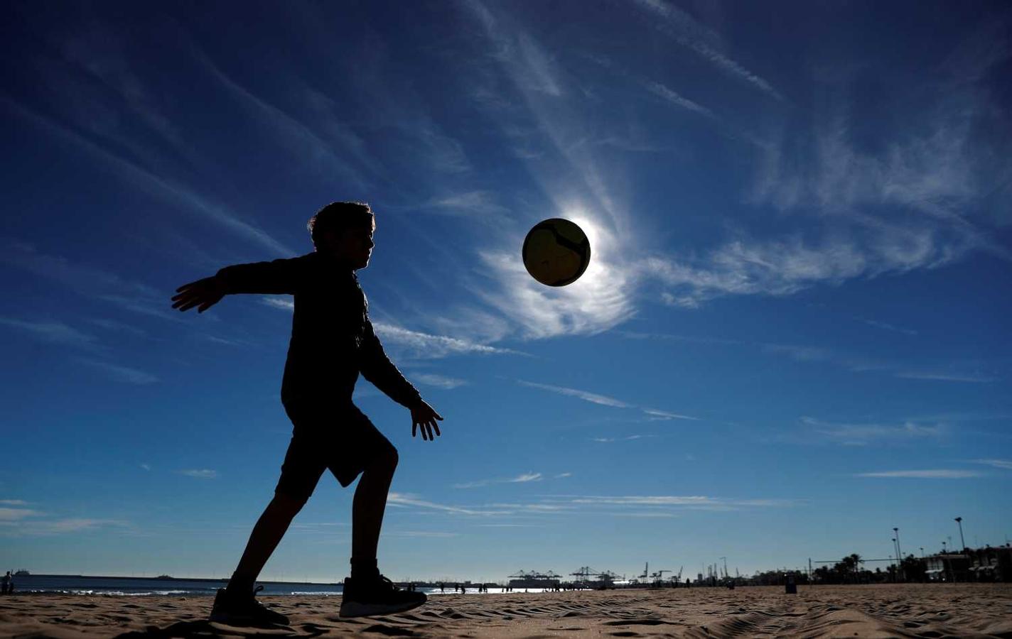 Un niño juega en la playa de la Malvarrosa en Nochebuena