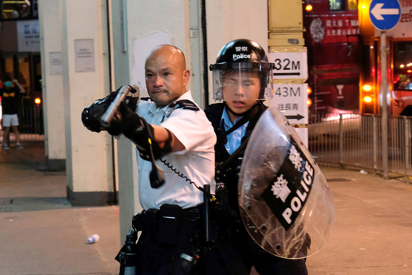 Hong Kong | Un policía apunta con un arma a los manifestantes contra el proyecto de ley de extradición que, en ese momento, rodeaban una comisaría , 30 de julio de 2019. /