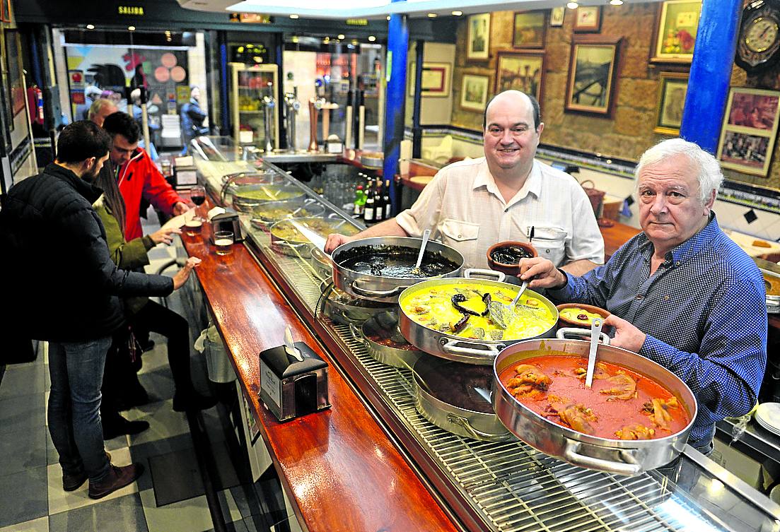 Río Oja (Bilbao).  El Río Oja es uno de los escasos feudos que les quedan a los txikiteros de la vieja escuela, esos que aún no se han rendido al imperio del pintxo y siguen despachando sus delicias en cazuela de barro. La cocina no es precisamente sofisticada, los camareros puede que no sepan decir lisonjas en cinco idiomas, pero este sitio tiene algo imposible de manufacturar: autenticidad. Y eso entusiasma a los guiris y fideliza a los indígenas. El bacalao al pil pil, los txipirones en su tinta y la casquería son una delicia.