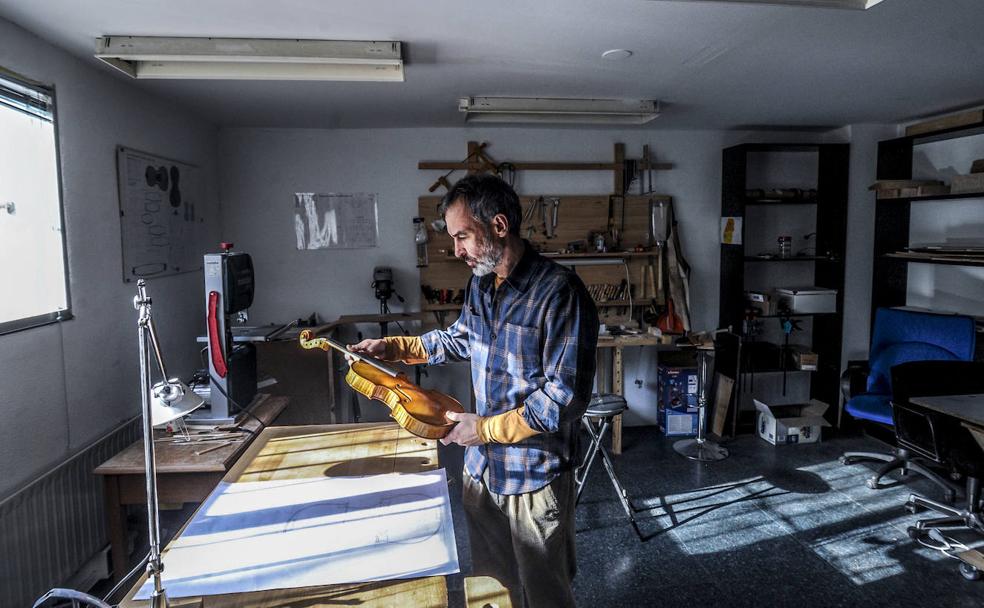 La luz entra por una ventana enrejada en el taller del luthier.