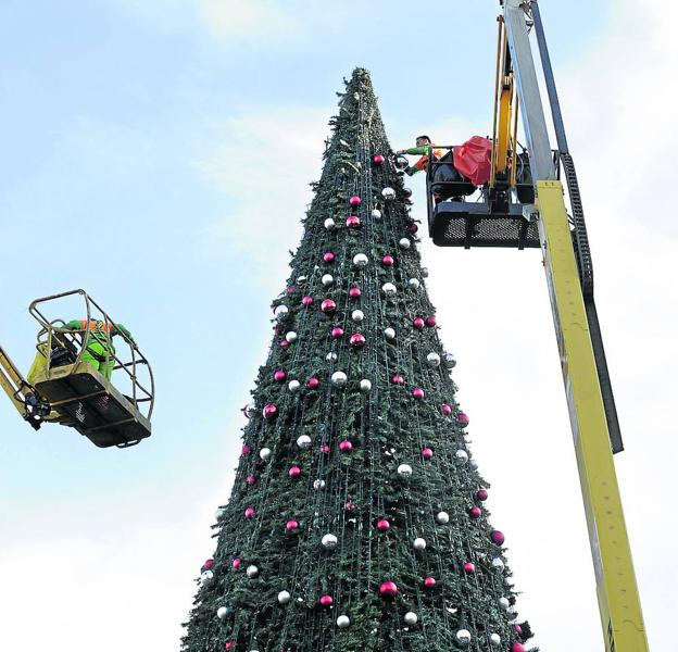 Operarios trabajan para desmontar el árbol que ha presidido la plaza del Arriaga estas semanas.