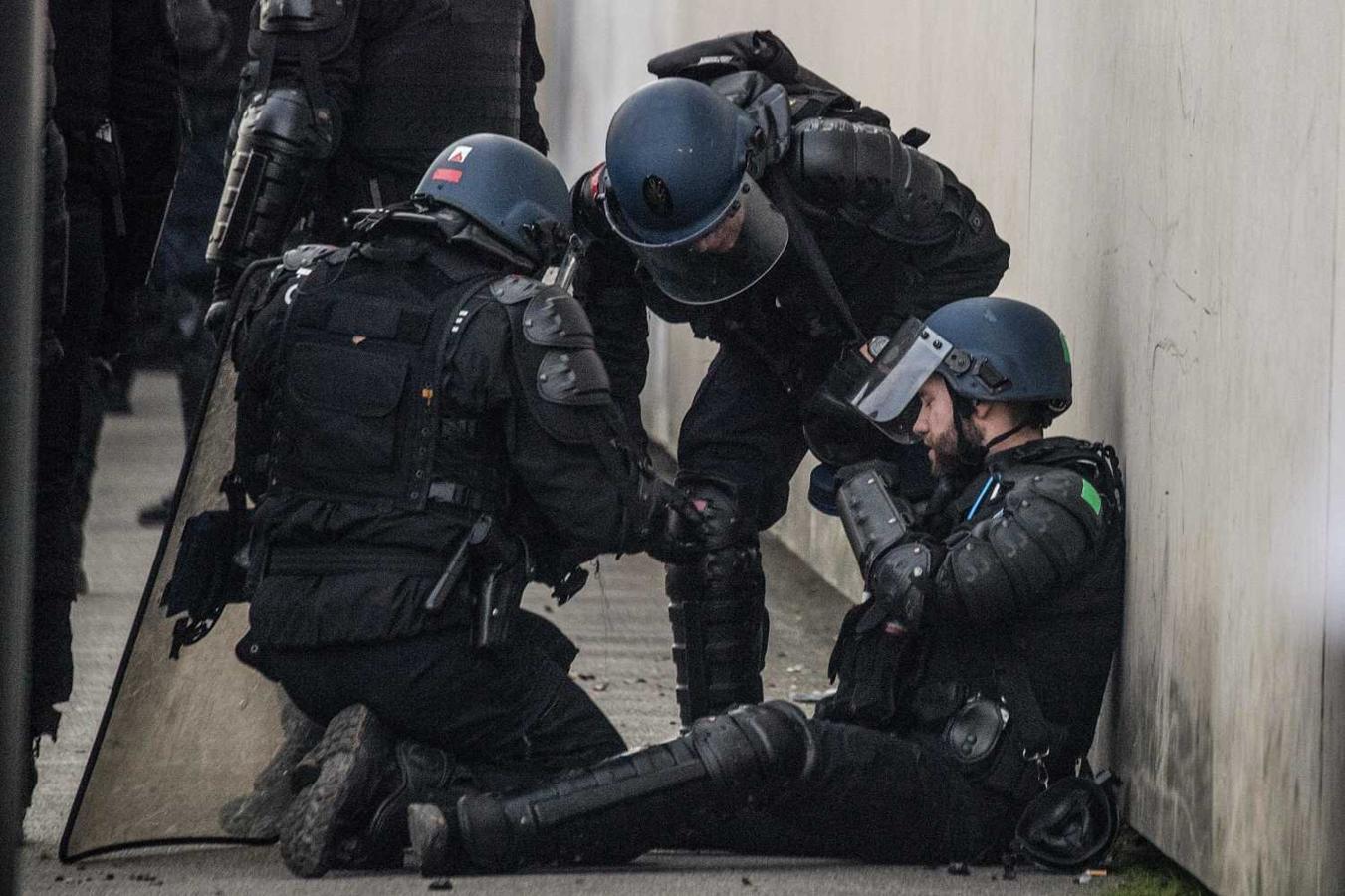 Policías franceses atienden con un compañero herido durante una protesta en Nantes, Francia