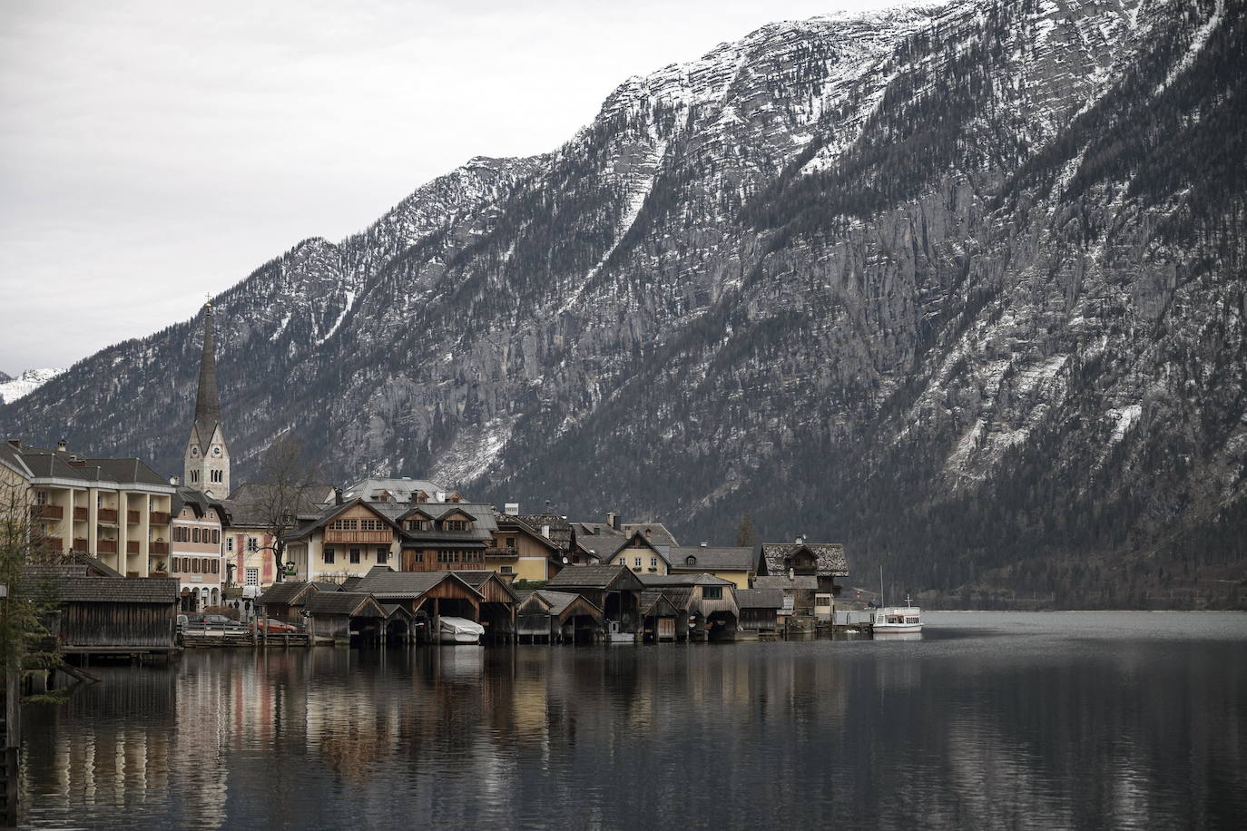 Hallstatt era hace diez años una villa idílica al borde de un lago de ensueño y aún lo sigue siendo, pero de otra manera. Lo que entonces le faltaba al pequeño pueblo austriaco, ahora le sobra. Tiene gente para dar y regalar, la hay por todas partes, tanta que hasta los visitantes se cuelan sin permiso en las casas en busca de un baño que no esté ocupado. En el pueblo residen 778 vecinos pero no lo parece porque apenas se les ve. Su presencia se diluye ante las riadas de personas que transitan por las calles en busca de un lugar vacío donde sacarse una foto mientras decenas de drones sobrevuelan los tejados para obtener imágenes impactantes. Hay turistas que llegan a la localidad convencidos de que se encuentran en un parque temático donde todo es de cartón piedra y todo está a la venta. Otros creen que están recorriendo el auténtico Arendelle, el reino de la película 'Frozen'. Hallstatt es un pueblo de moda, hasta ha sido calificado como «el más 'instagrameable' del mundo», y eso está siendo su ruina