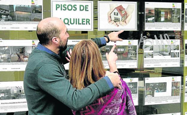 Una pareja revisa anuncios inmobiliarios. 