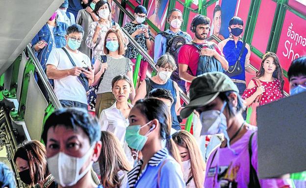 Ciudadanos tailandeses siguen los protocolos de prevención en una estación de tren en Bangkok.