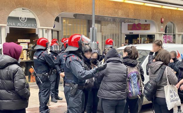 Ertzainas con varias de las manifestantes en la calle General Álava tras recuperar los carritos.