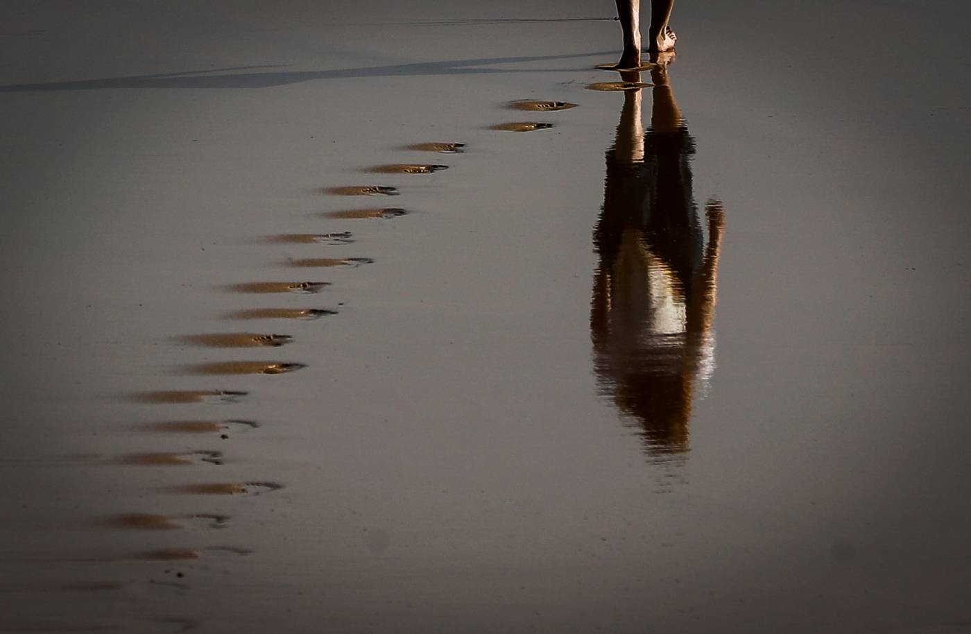 Una mujer pasea por la orilla de la playa de Ondarreta de San Sebastián, donde los cielos se presentan poco nubosos o despejados con algunos intervalos de nubes altas de madrugada y al final del día e intervalos de nubes bajas en el litoral al final de la jornada, las temperaturas mínimas irán en descenso y las máximas subirán mientras los vientos soplarán flojos de sur con tendencia a oeste en la costa. 