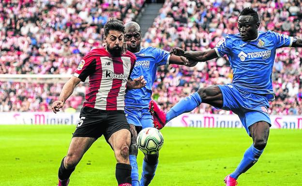 Villalibre, Nyom y Djene, de izquierda a derecha, pugnan por el control de la pelota.