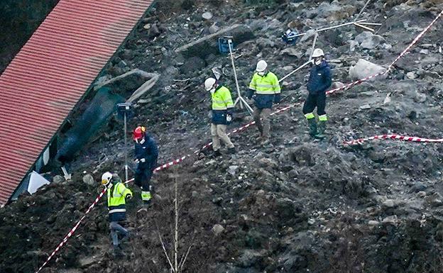 Un grupo de operarios junto a parte de los materiales que se precipitaron sobre la autopista. 