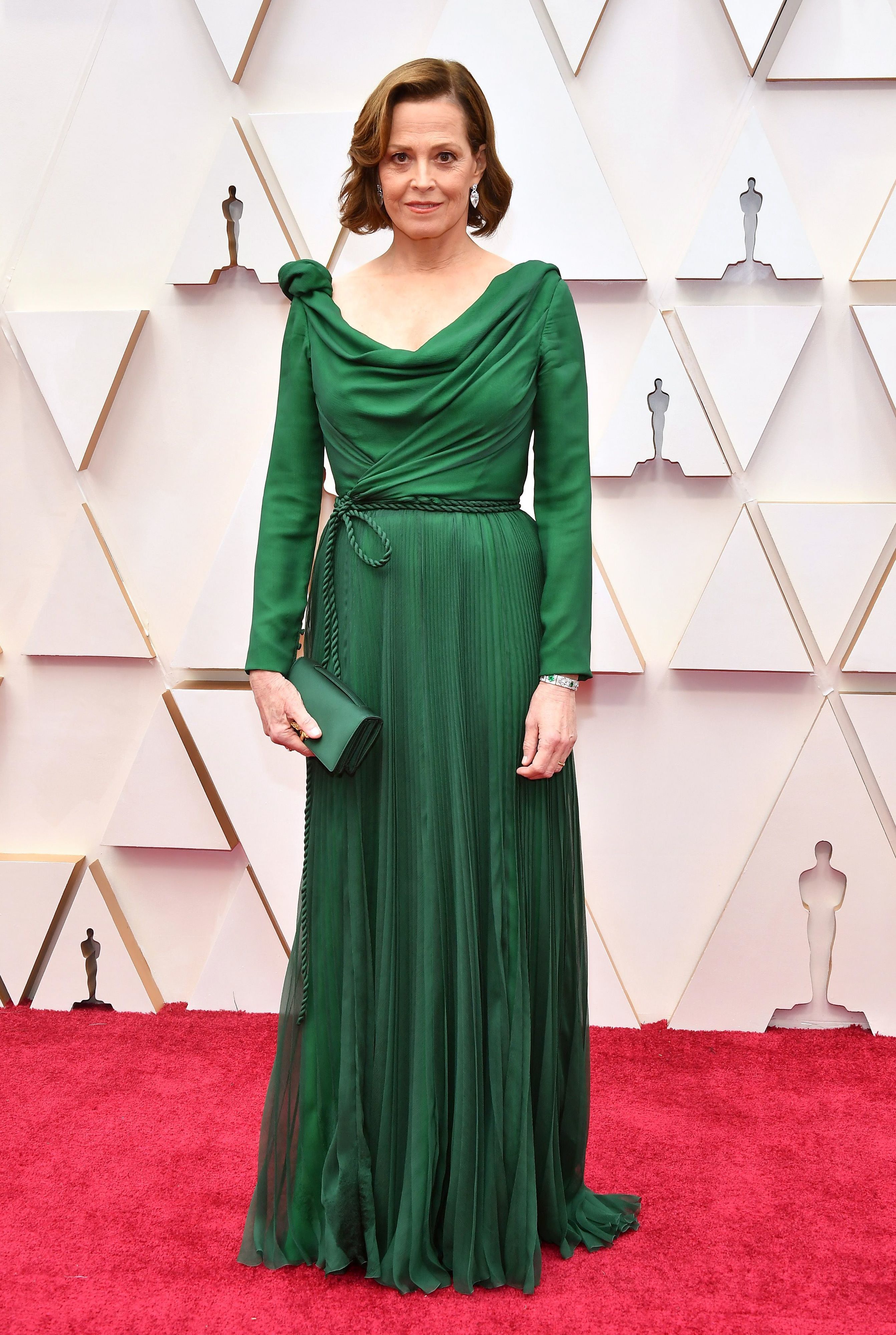 Sigourney Weaver, muy elegante con un diseño verde botella de Christian Dior. De reminiscencias helénicas, tiene un cuerpo de escote asimétrico y drapeado, manga larga, falda plisada y enmarca su cintura con un cordón de raso anudado en el lateral.