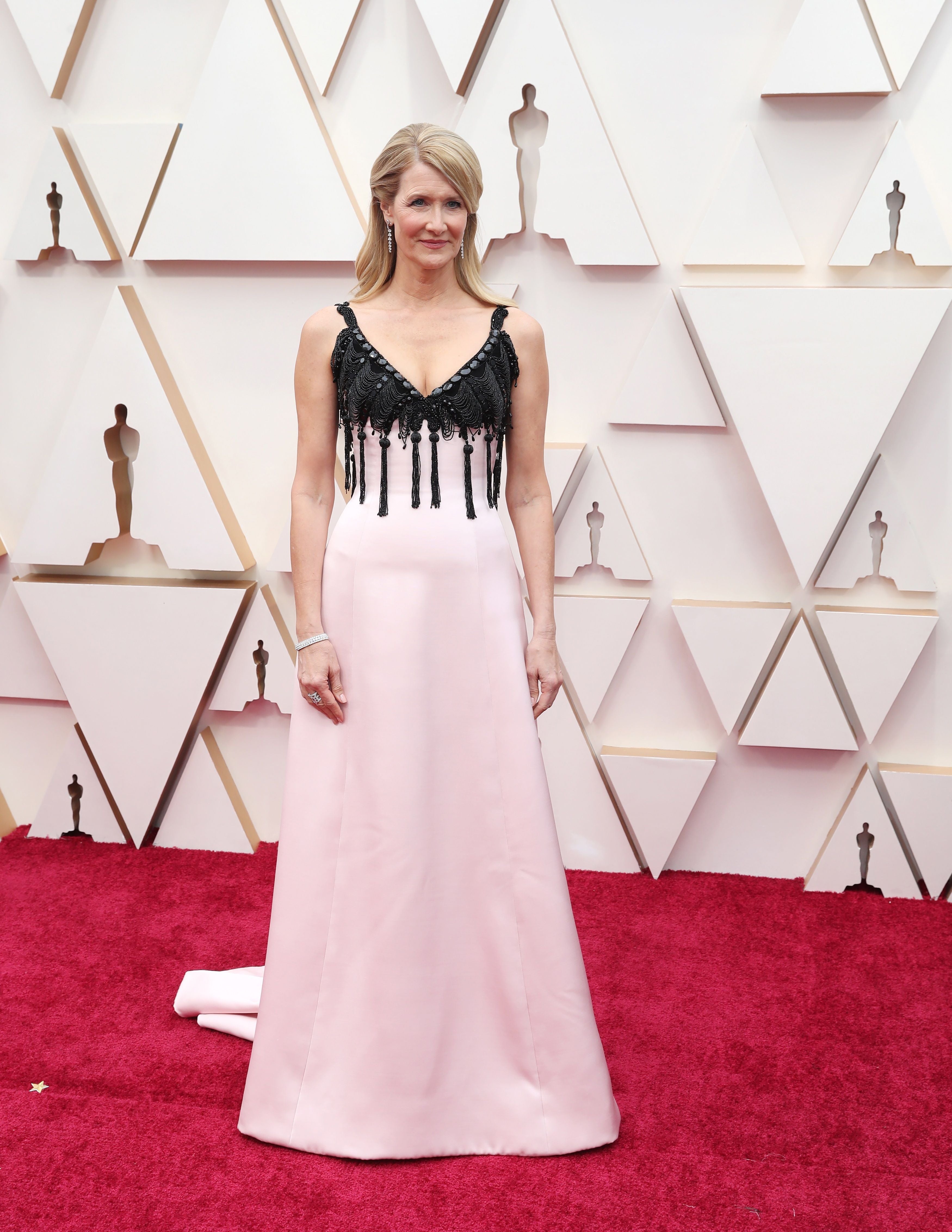 Laura Dern está arrasando en las últimas entregas de premios y es indiscutiblemente favorita en esta 92º edición de los Oscar en la categoría de ‘Mejor Actriz secundaria’. La estadounidense, que interpreta a una beligerante abogada en ‘Historia de un matrimonio’, vuelve a seguir con su propia filosofía del ‘menos es más’ y apuesta por un diseño bicolor de Armani Privé, con falda rematada en cola y cuerpo de tirantes, con escote en ‘v’ y bordados de pedrería y borlas.