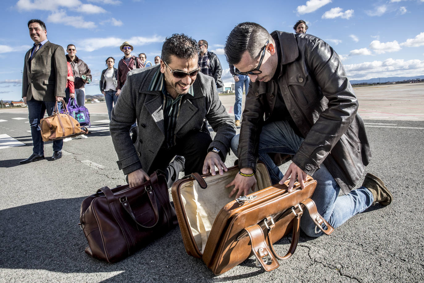 Los pasajeros se dirigen a la terminal, con sus maletas y con las típicas ensaimadas mallorquinas. 