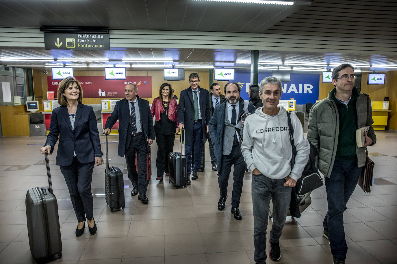 Mercedes Guerrero, Ramiro González, María Unceta-Barrenechea, Gorka Urtaran, Antonio Aiz, Pascal Gómez, Elena Loyo, Martín Fiz e Ivan Igartua caminan, con su equipaje, por la zona de facturación del aeropuerto de Foronda.