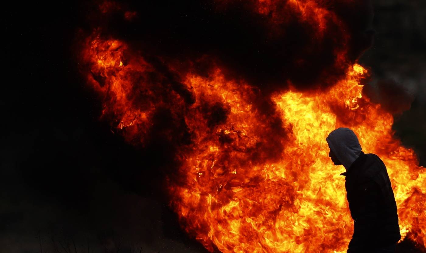 Un manifestante palestino busca refugio frente a las tropas israelíes durante enfrentamientos tras una protesta contra la propuesta de "Acuerdo del Siglo" hecha por el presidente estadounidense Donald Trump, en Ramala (Cisjordania). 