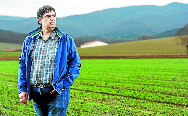 Javier Torre mira a un horizonte lleno de nubarrones en una finca de cultivo de los alrededores de Vitoria.