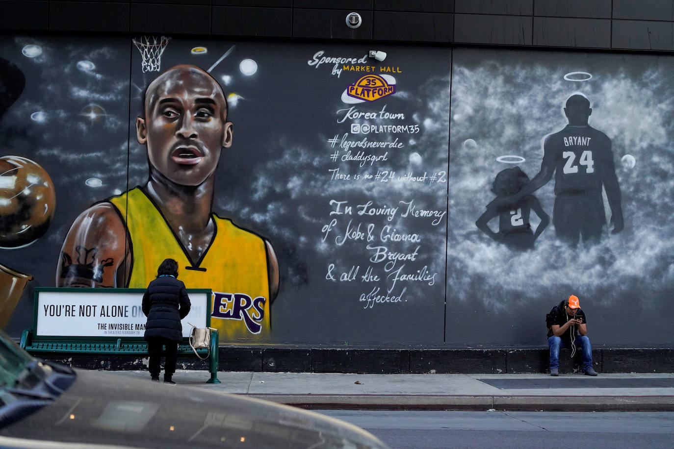 Dos transeúntes paran en la calle frente a otro de los murales pintados en las paredes de Los Angeles que rinden tributo al gran Kobe Bryant, leyenda de los Lakers, su hija Gigi y las otras siete personas que fallecieron junto a ellos en un accidente de helicóptero.