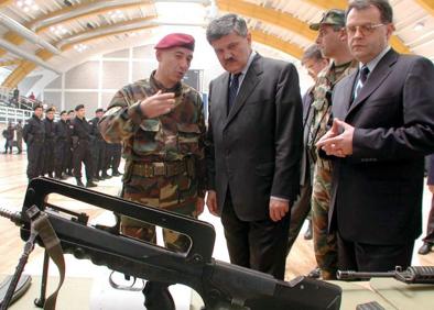 Imagen secundaria 1 - Covic brinda con Djindjic tras alcanzar el Gobierno, visita la presentación de los fusiles de asalto de la Policía especial como vice primer ministro y juega con la camiseta del club que patrocina la empresa de la que es el dueño.