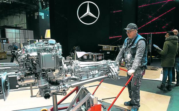 Un empleado retira un motor del stand de Mercedes en el Salón de Ginebra, que ha sido cancelado.