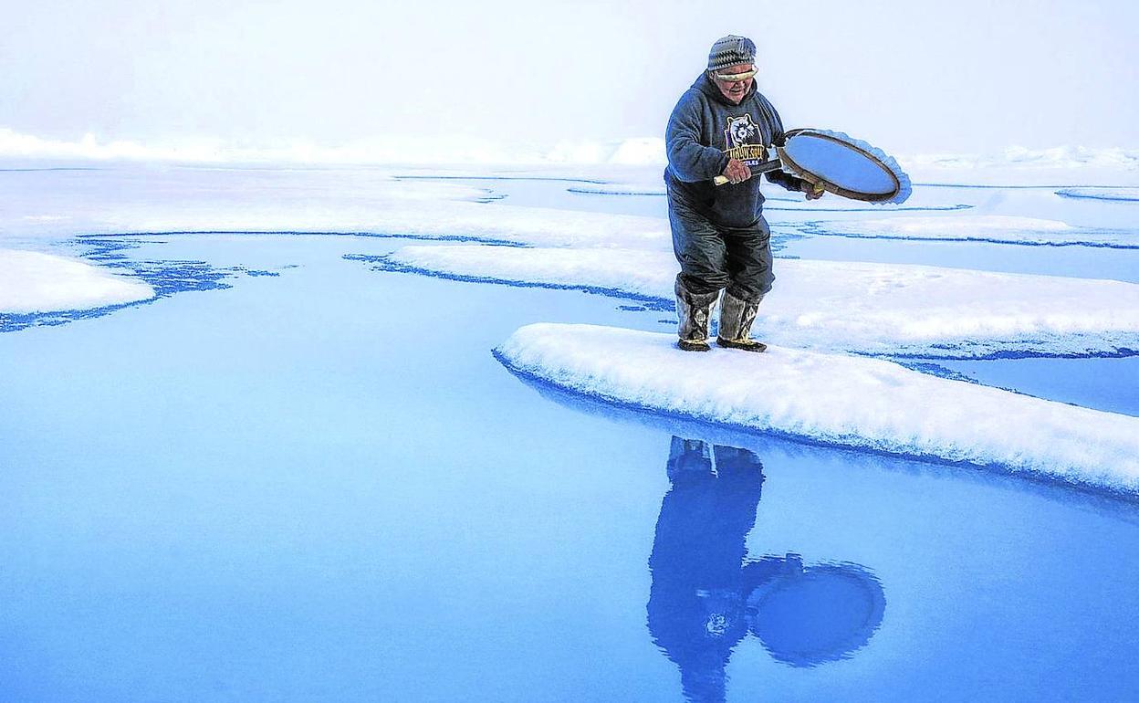 En soledad. Un inuit se refleja en el agua como símbolo del colapso de la capa de hielo en Groenlandia.