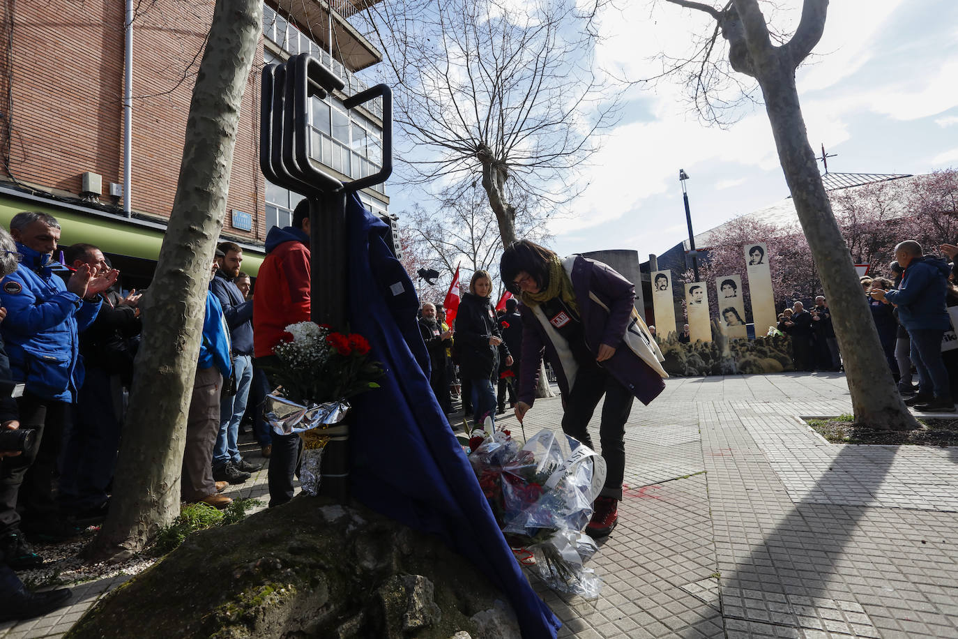 Representantes de LAB depositan claveles frente al monolito. 