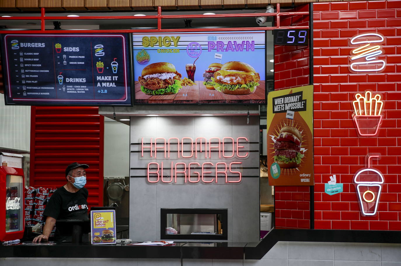 Un trabajador protegido con una mascarilla en una hamburguesería de la ciudad.