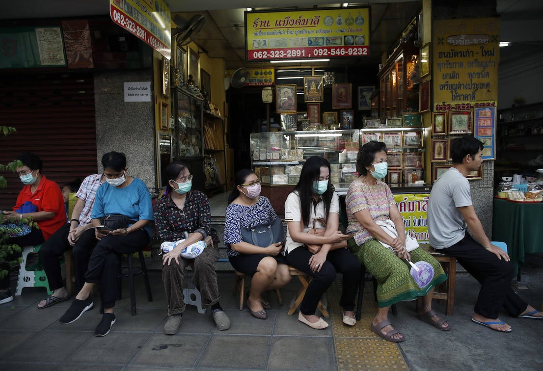 La gente hace cola para comprar mascarillas frente a una farmacia en Bangkok.