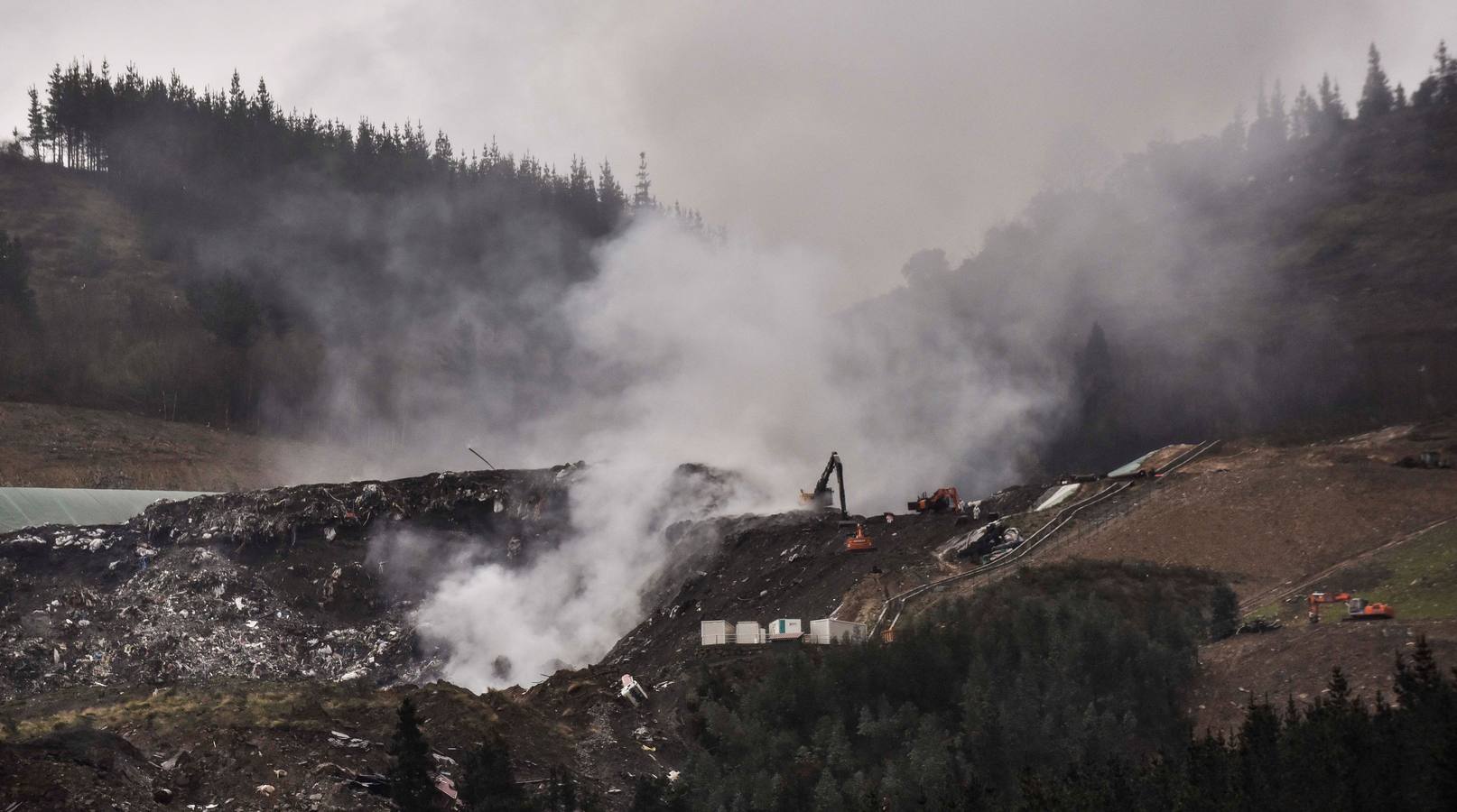 Varios operarios con maquinaria pesada trabajan en el rescate de los cuerpos de los dos trabajadores.