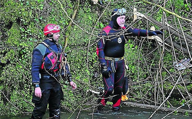 Imagen principal - Una veintena de submarinistas de distintos cuerpos de emergencia trabajaron para encontrar el vehículo en el Urumea. | Familiares y conocidos de los accidentados aguardan frente a un caserío los resultados del rescate. | Una grúa logró extraer el coche del río pasadas las 21.00 horas.