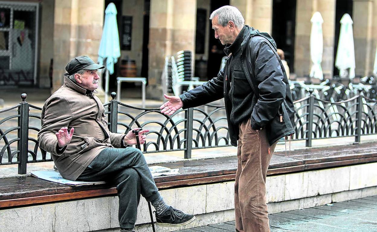 En la Plaza Nueva, Santos Aparicio explica a un amigo que no hay que estrecharse la mano. 