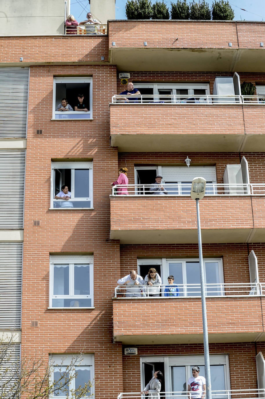 Los vecinos se comunican desde sus balcones en esta jornada festiva.