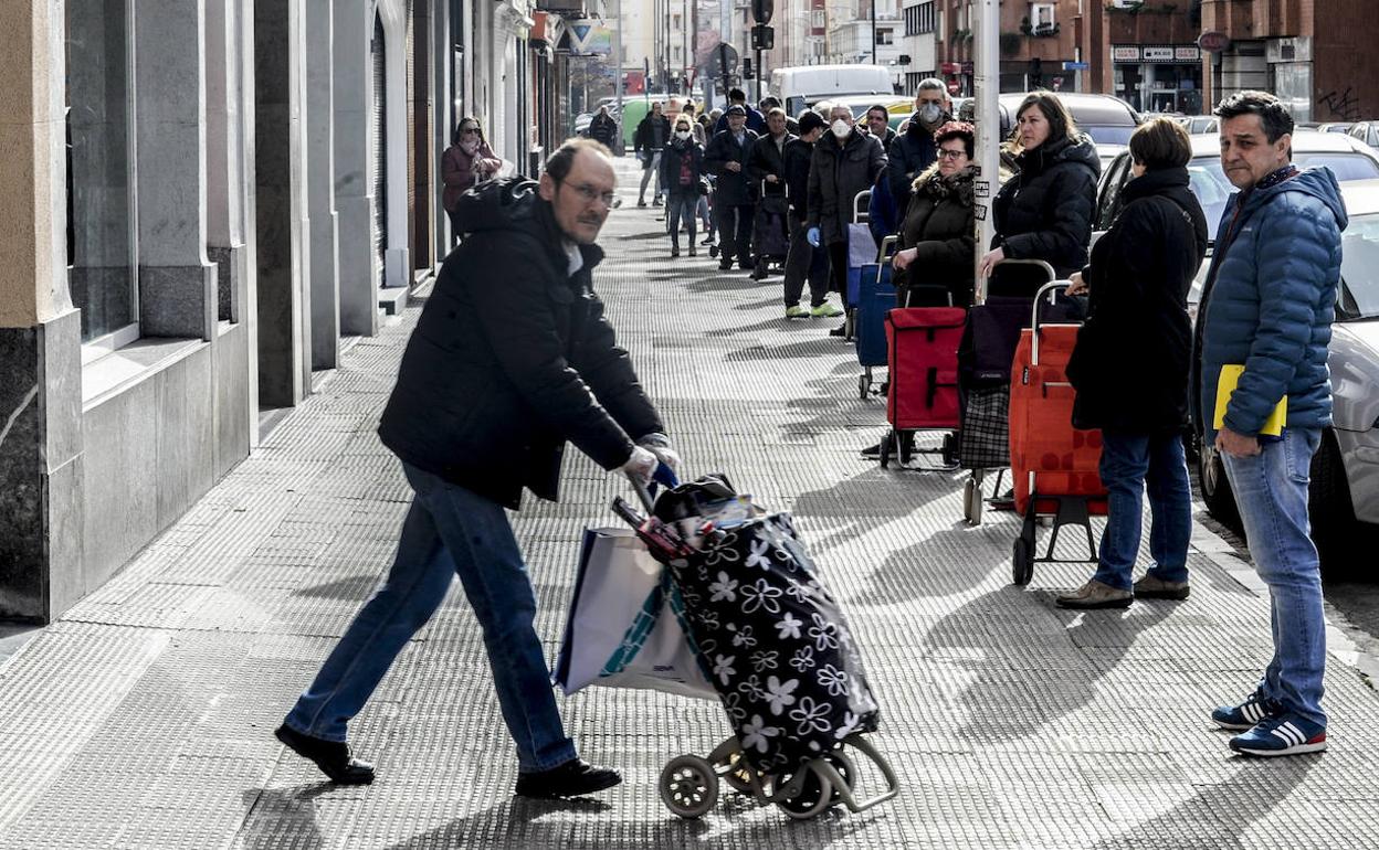 Largas filas para acceder al supermercado en la calle Beato Tomás de Zumárraga. 