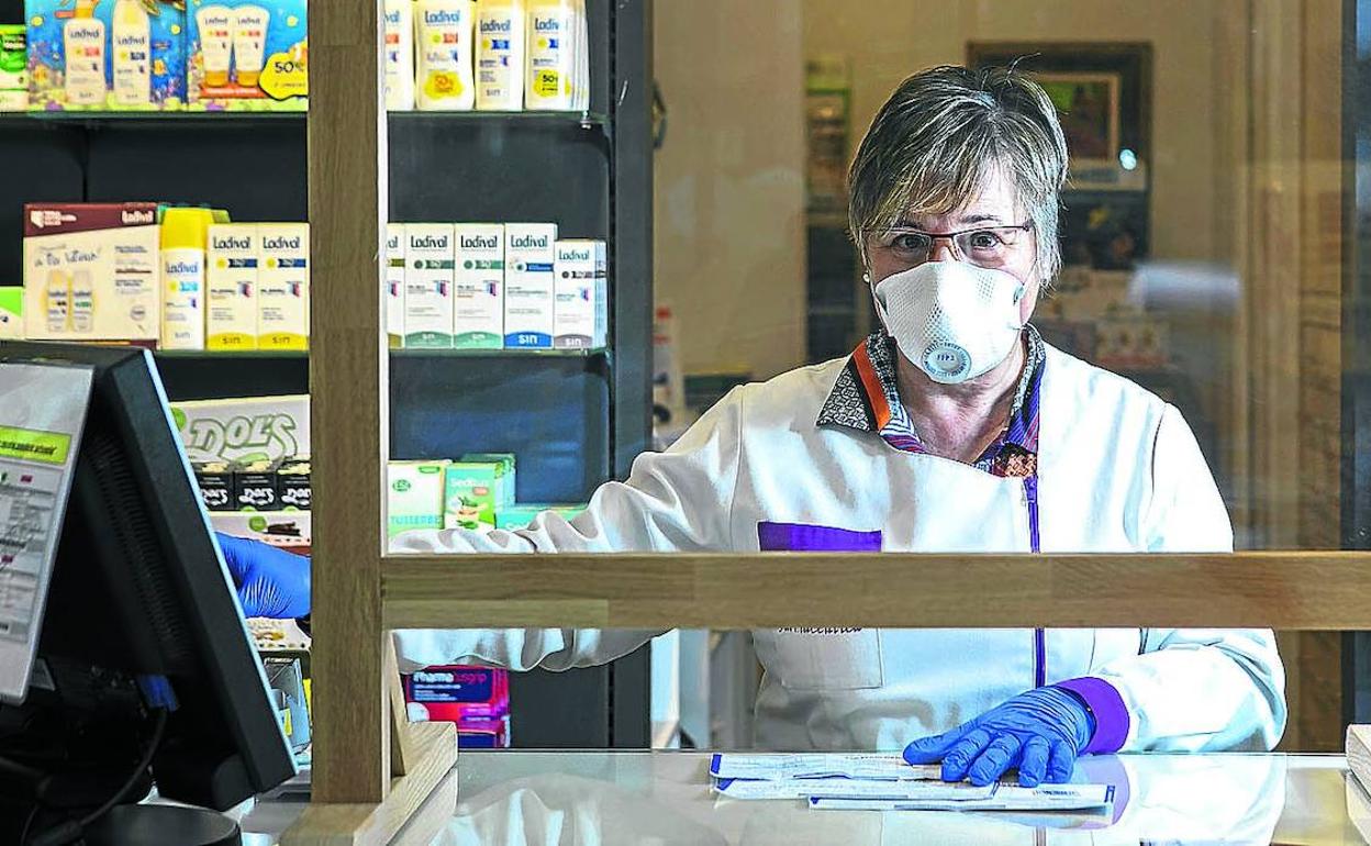 Karmele Mendiaratz atiende desde hace días con guantes y mascarilla en su farmacia de El Pilar. 