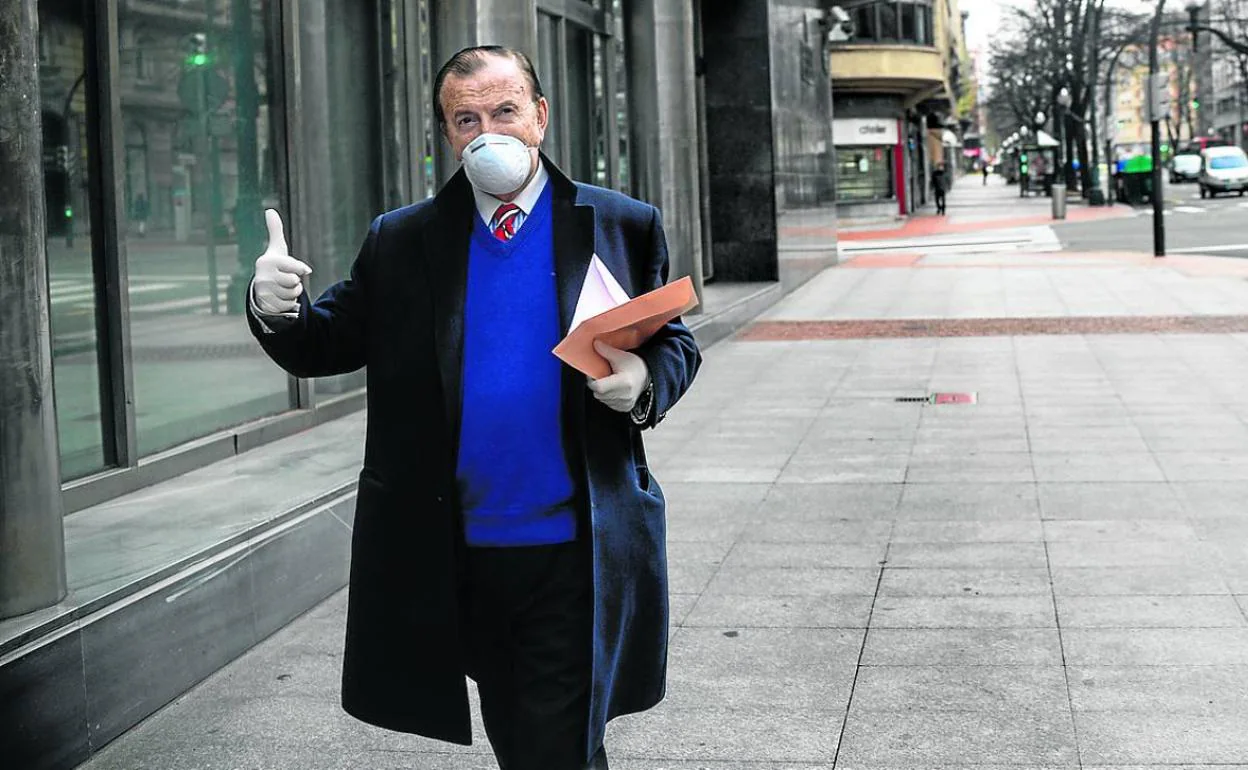 Un hombre con mascarilla y guantes transita por un Bilbao casi desierto.